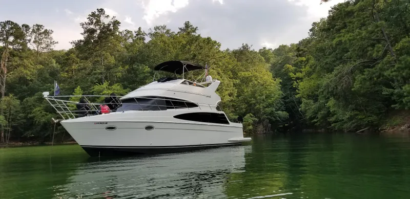  Yacht Photos Pics 2004 Carver 360 Sport Sedan yacht on a serene lake surrounded by lush trees.