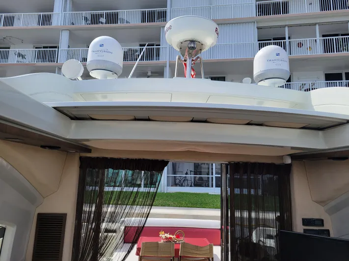 Fantasia 04 Yacht Photos Pics 2009 Azimut 43S yacht with radar domes, docked near a modern building.