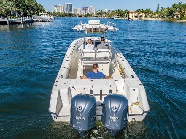  Yacht Photos Pics 2010 Edgewater 318CC boat cruising on a scenic waterway with three passengers.