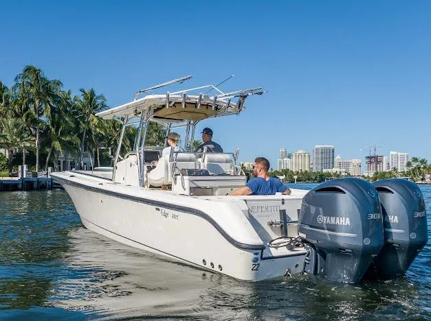  Yacht Photos Pics 2010 Edgewater 318CC boat cruising on water with Yamaha engines, city skyline in background.