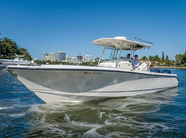  Yacht Photos Pics 2010 Edgewater 318CC boat cruising on a sunny day near a city skyline.