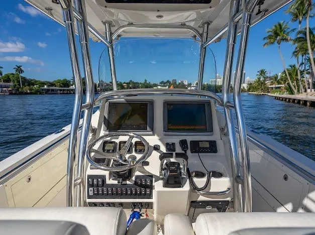  Yacht Photos Pics Cockpit view of 2010 Edgewater 318CC boat with dual screens and steering wheel on a sunny day.
