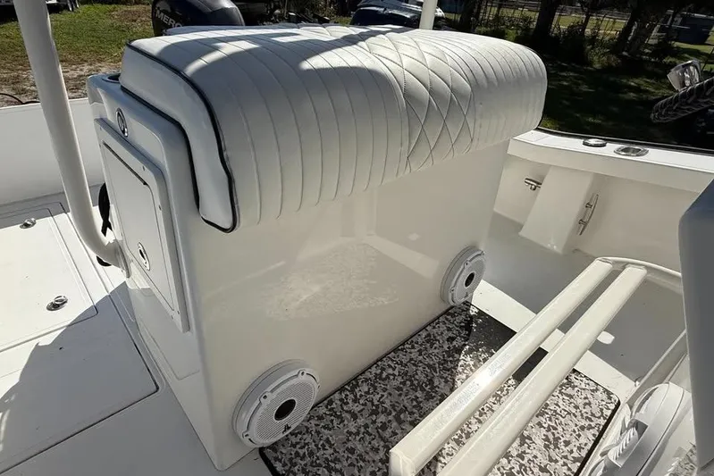  Yacht Photos Pics White cushioned seat on a 2015 Calcutta 263 boat, featuring storage and speakers.