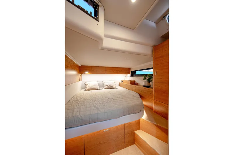  Yacht Photos Pics Luxurious cabin interior of 2026 Hanse 590 yacht with cozy bed and wooden accents.