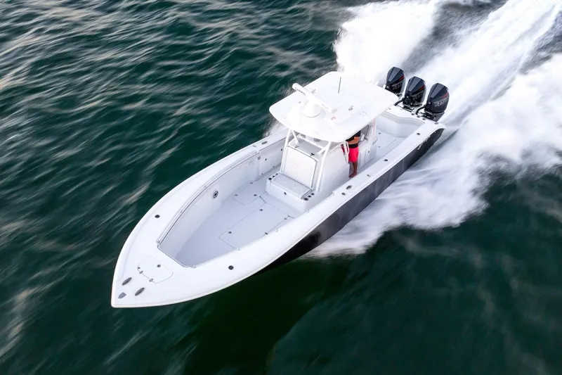  Yacht Photos Pics 2023 Yellowfin 34 boat speeding on open water, showcasing sleek design and powerful engines.