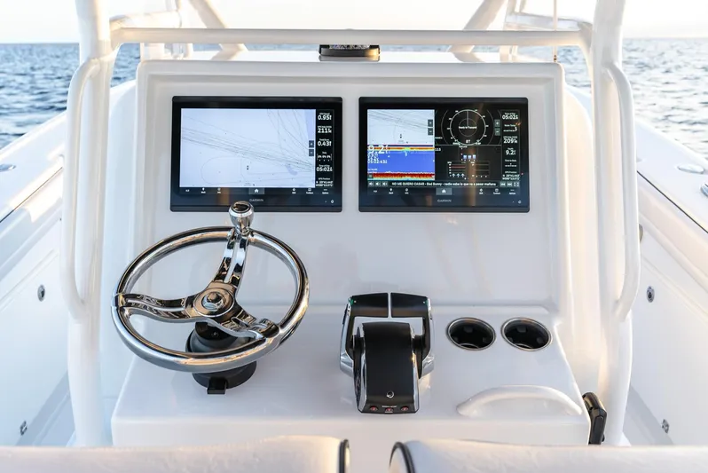  Yacht Photos Pics 2023 Yellowfin 34 boat dashboard with dual screens and steering wheel, ocean in background.