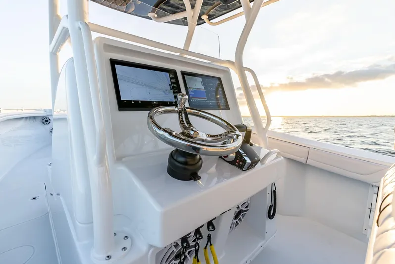  Yacht Photos Pics 2023 Yellowfin 34 boat console with dual screens and steering wheel at sunset.