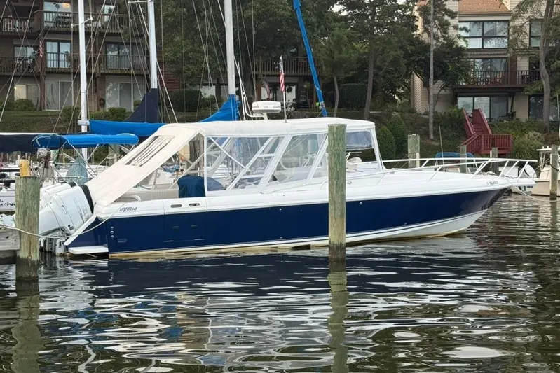 Mac & Seas Yacht Photos Pics 2000 Intrepid 356 Cuddy boat docked in a marina, surrounded by water and buildings.