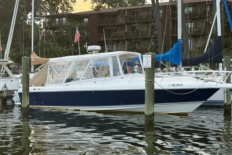 Mac & Seas Yacht Photos Pics 2000 Intrepid 356 Cuddy boat docked in marina, surrounded by sailboats.