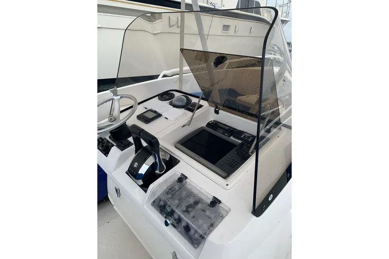 Mac & Seas Yacht Photos Pics Control panel of a 2000 Intrepid 356 Cuddy boat with steering wheel and navigation equipment.