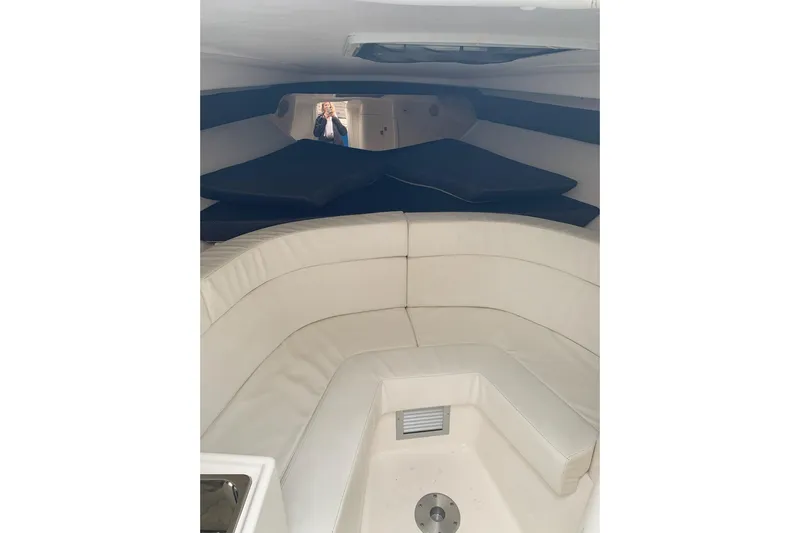 Mac & Seas Yacht Photos Pics Interior of a 2000 Intrepid 356 Cuddy boat with white seating and blue accents.