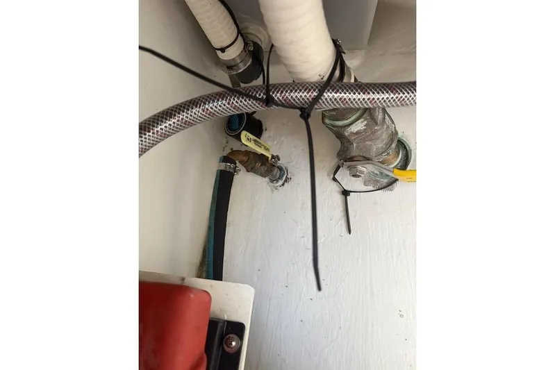 Mac & Seas Yacht Photos Pics Plumbing components inside a 2000 Intrepid 356 Cuddy boat, featuring hoses and valves.