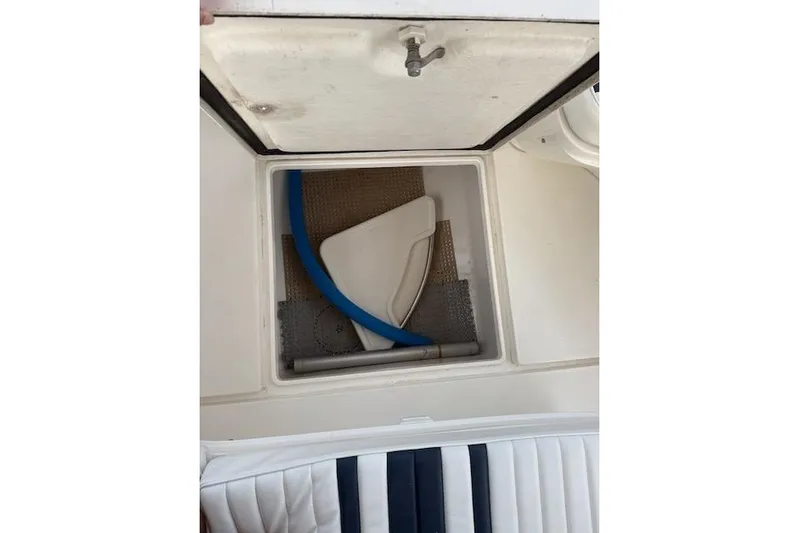 Mac & Seas Yacht Photos Pics Storage compartment on a 2000 Intrepid 356 Cuddy boat, featuring a blue hose.