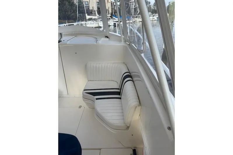 Mac & Seas Yacht Photos Pics Interior of 2000 Intrepid 356 Cuddy boat with white seating and striped cushions.