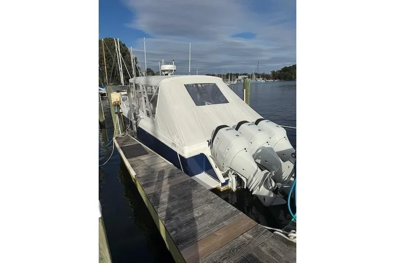 Mac & Seas Yacht Photos Pics 2000 Intrepid 356 Cuddy boat docked with covered cabin and triple outboard motors.