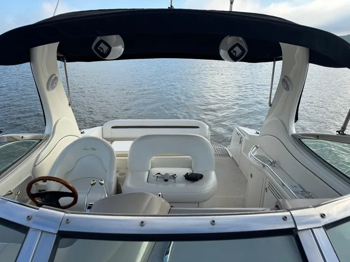  Yacht Photos Pics 2004 Sea Ray 360 Sundancer boat interior with seating and steering wheel, overlooking calm water.