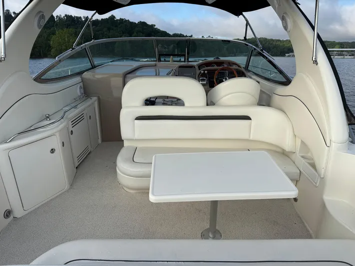  Yacht Photos Pics 2004 Sea Ray 360 Sundancer interior with white seating and table, overlooking a serene lake.