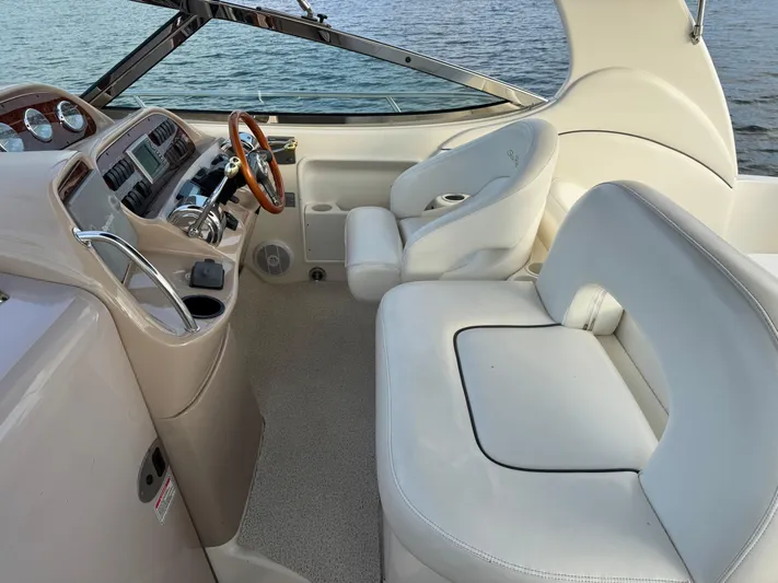  Yacht Photos Pics 2004 Sea Ray 360 Sundancer cockpit with white seating and wooden steering wheel.