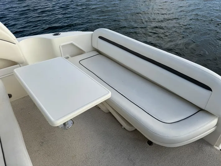  Yacht Photos Pics 2004 Sea Ray 360 Sundancer boat interior with white seating and table by the water.