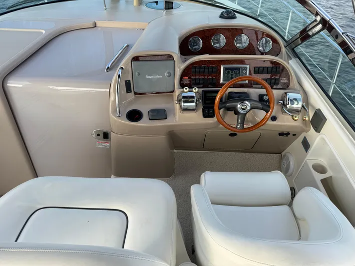  Yacht Photos Pics 2004 Sea Ray 360 Sundancer helm with wood accents and modern controls.