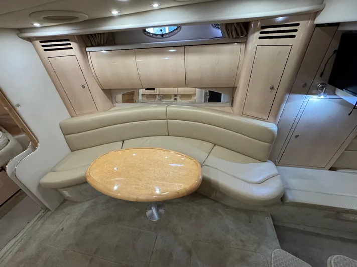  Yacht Photos Pics Luxurious interior of 2004 Sea Ray 360 Sundancer with beige seating and wooden table.