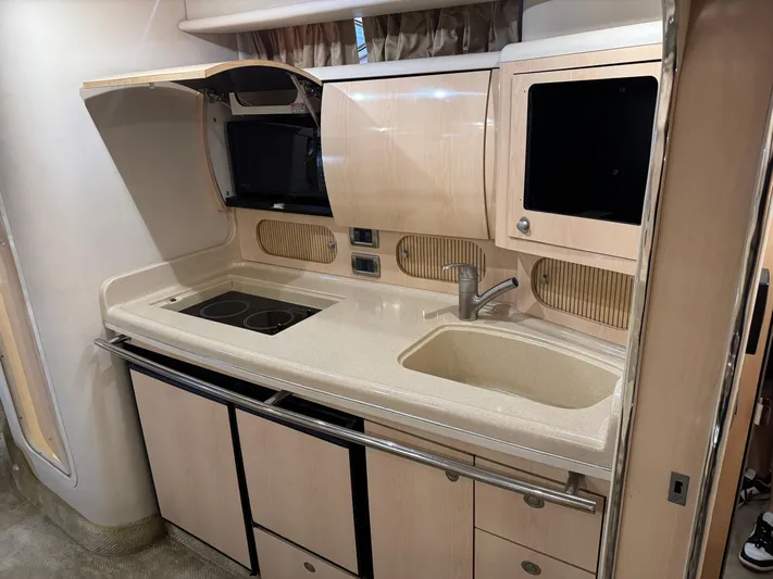  Yacht Photos Pics 2004 Sea Ray 360 Sundancer yacht kitchen with sink, stove, and storage cabinets.