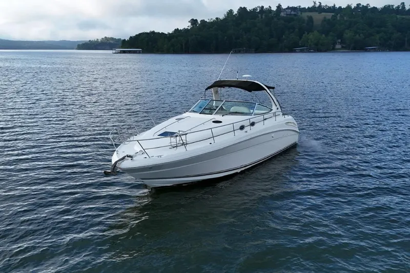  Yacht Photos Pics 2004 Sea Ray 360 Sundancer cruising on a serene lake with forested shoreline.