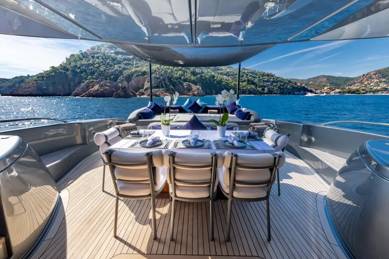 Silver Breeze Yacht Photos Pics Luxurious dining setup on 2010 Riva Domino 86 yacht, overlooking scenic ocean and hills.