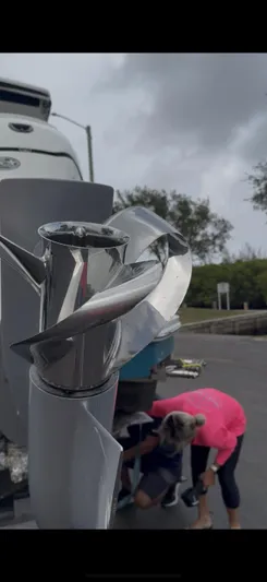  Yacht Photos Pics Close-up of a 2022 Sea Ray Sundancer 320 Outboard propeller with people in the background.