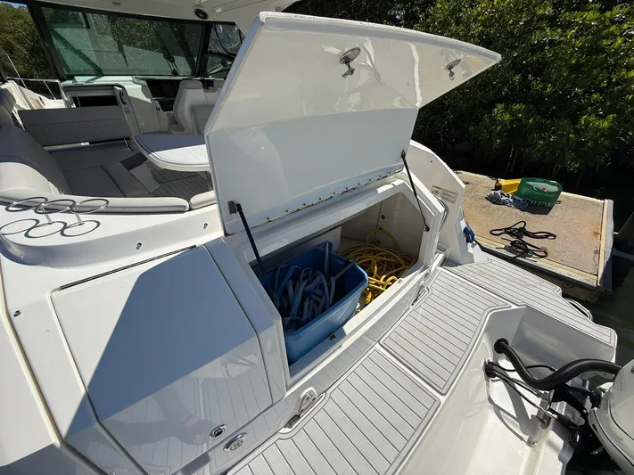  Yacht Photos Pics 2022 Sea Ray Sundancer 320 Outboard with open storage compartment and dock view.