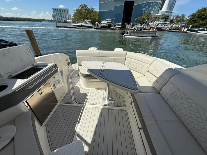  Yacht Photos Pics Luxurious 2022 Sea Ray Sundancer 320 Outboard boat interior with seating and table, docked by the water.