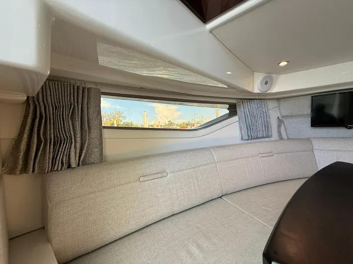  Yacht Photos Pics 2022 Sea Ray Sundancer 320 Outboard interior with plush seating and window view.