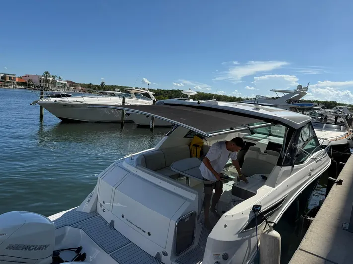  Yacht Photos Pics 2022 Sea Ray Sundancer 320 Outboard docked, with a person onboard under a clear blue sky.