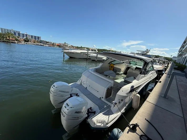  Yacht Photos Pics 2022 Sea Ray Sundancer 320 Outboard docked by waterfront, featuring dual Mercury engines.