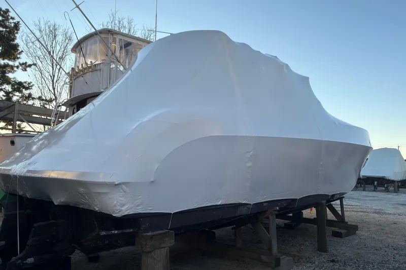  Yacht Photos Pics 1999 Formula 400 Super Sport boat covered in protective wrap, stored outdoors.