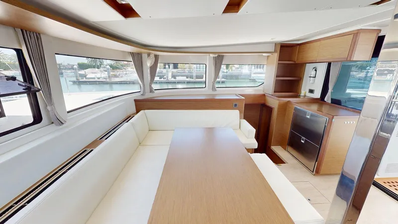 Sliver Fern Yacht Photos Pics Interior of 2020 Lagoon 46 yacht with modern dining area and panoramic windows.