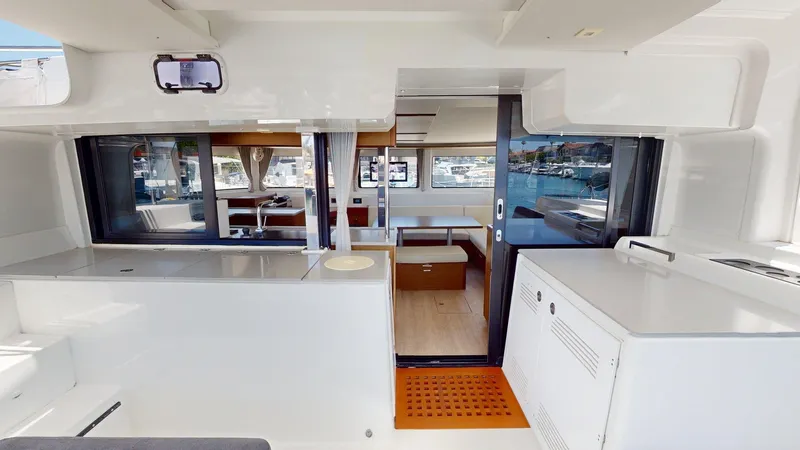 Sliver Fern Yacht Photos Pics Interior of 2020 Lagoon 46 catamaran, featuring modern kitchen and dining area with marina view.