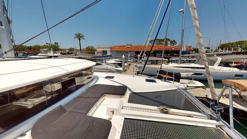 Sliver Fern Yacht Photos Pics 2020 Lagoon 46 catamaran docked at marina, featuring spacious deck and modern design.