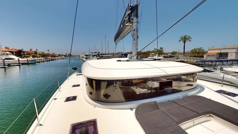 Sliver Fern Yacht Photos Pics 2020 Lagoon 46 catamaran docked in a sunny marina, showcasing sleek design and spacious deck.