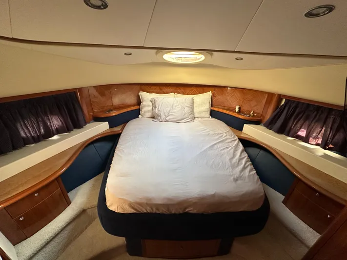  Yacht Photos Pics Luxurious bedroom interior of 2003 Aicon 56 Flybridge yacht with cozy bed and elegant wood accents.