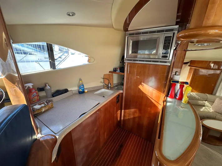  Yacht Photos Pics Interior of 2003 Aicon 56 Flybridge yacht kitchen with wood finish and appliances.