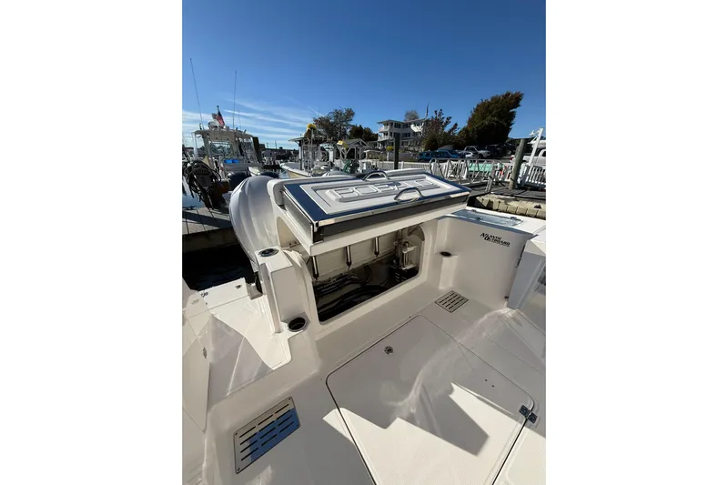  Yacht Photos Pics 2025 Robalo R300 Center Console boat at marina, showcasing open storage compartment.
