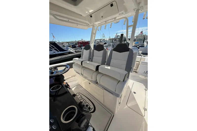  Yacht Photos Pics 2025 Robalo R300 Center Console boat interior with three cushioned seats and steering area.