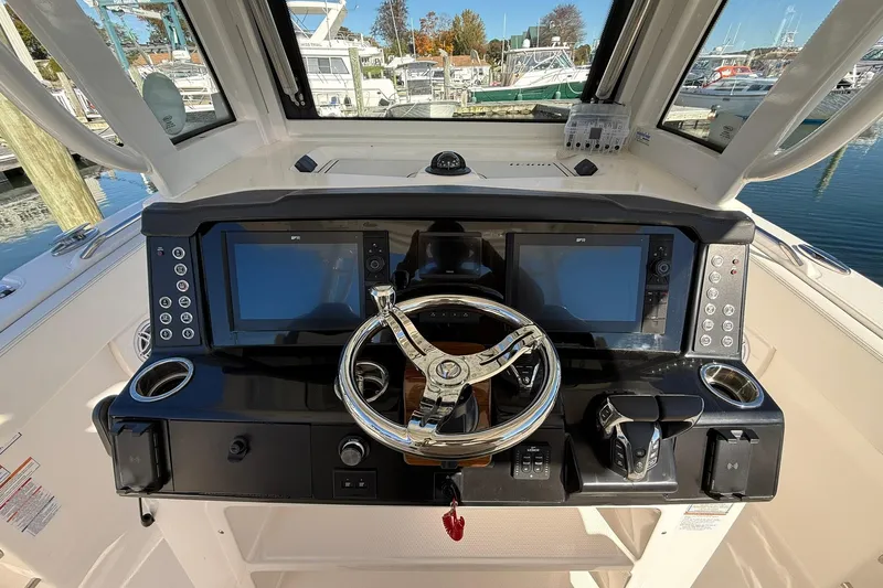 Yacht Photos Pics 2025 Robalo R300 Center Console helm with dual screens and modern controls.