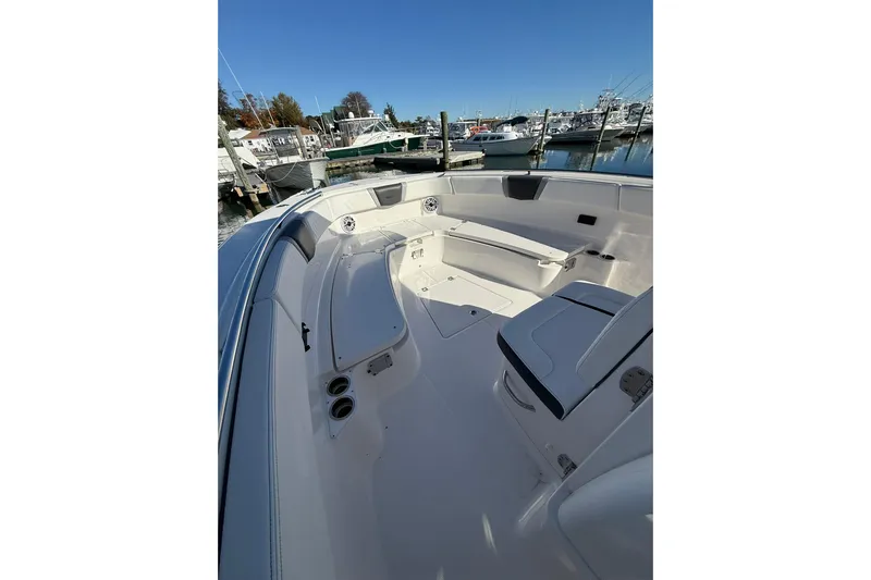  Yacht Photos Pics 2025 Robalo R300 Center Console boat interior at marina, featuring seating and storage.