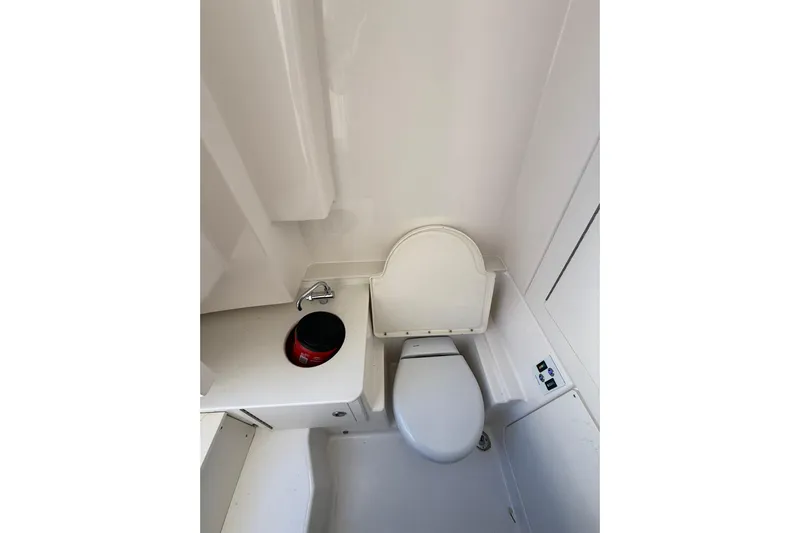  Yacht Photos Pics 2025 Robalo R300 Center Console boat interior with compact marine toilet.