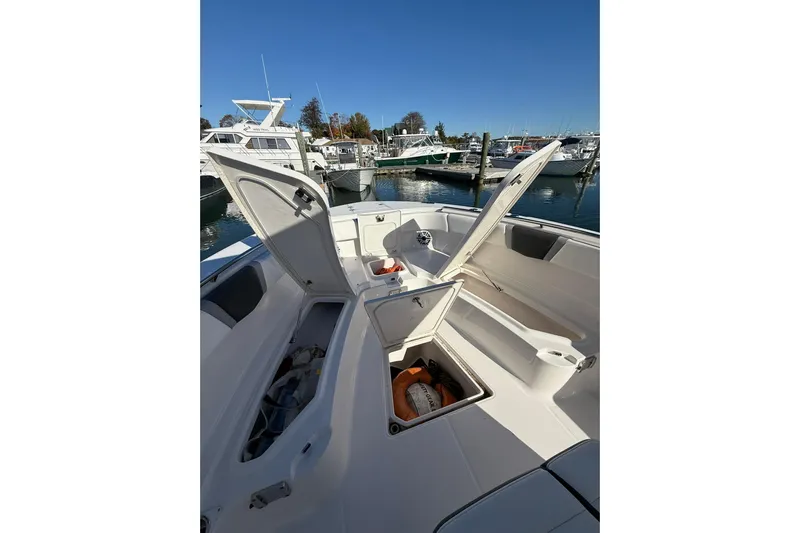  Yacht Photos Pics 2025 Robalo R300 Center Console boat with open storage compartments at a marina.