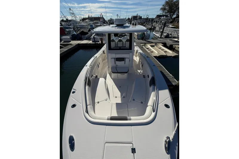  Yacht Photos Pics 2025 Robalo R300 Center Console boat docked at marina, showcasing spacious deck design.