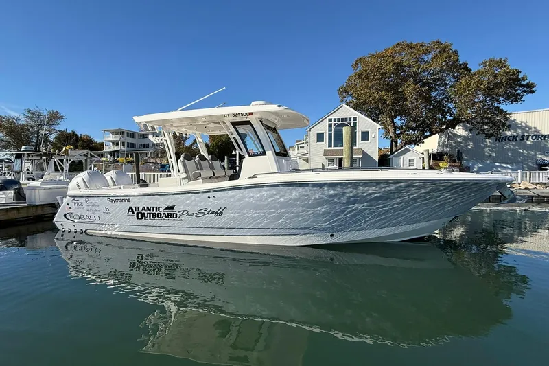  Yacht Photos Pics 2025 Robalo R300 Center Console boat docked in a marina, under clear blue skies.