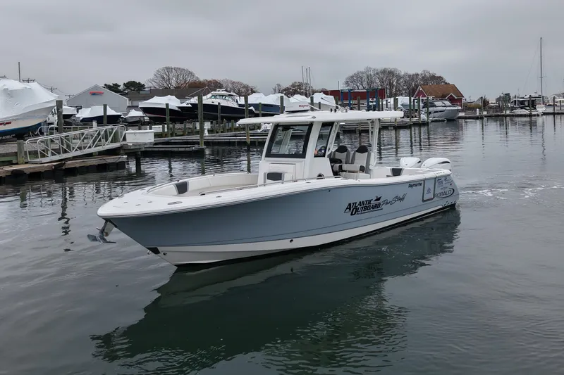  Yacht Photos Pics 2025 Robalo R300 Center Console boat docked in a marina on a cloudy day.